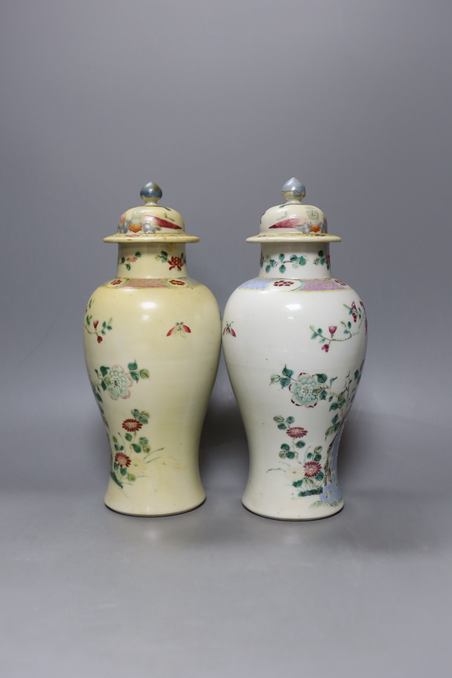 A pair of 19th century Chinese famille rose vases and covers - 27cm tall